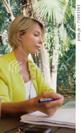 vertically. businesswoman holding video conference via laptop in an outdoor cafe vertically. businesswoman holding video conference via laptop in an outdoor cafe 71603363