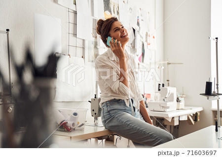 Designer using smartphone while sitting Designer using smartphone while sitting 71603697