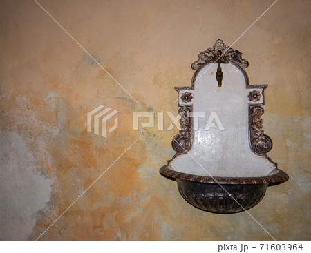 An old wash basin on a rustic wall 71603964