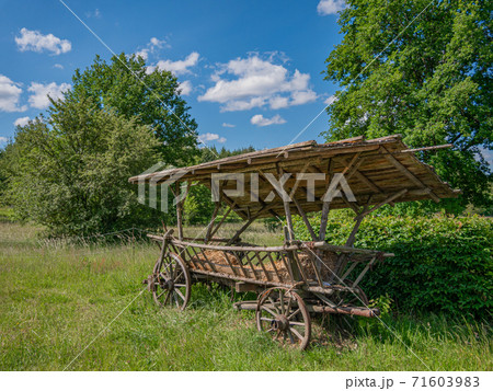 An old hay cart with wooden wheels and wooden roof An old hay cart with wooden wheels and wooden roof 71603983