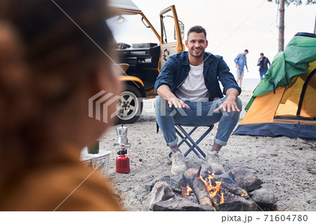Friends sitting near bonfire Friends sitting near bonfire 71604780