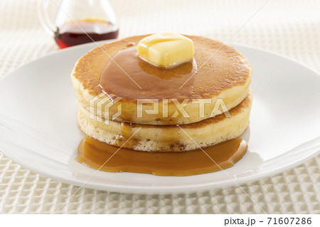 積み重ねたホットケーキにメープルシロップをかけて食べる 71607286