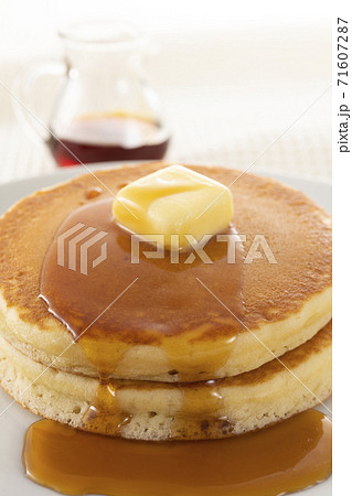 積み重ねたホットケーキにメープルシロップをかけて食べる 71607287