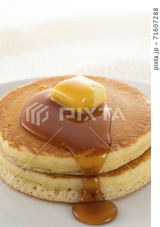 積み重ねたホットケーキにメープルシロップをかけて食べる 71607288