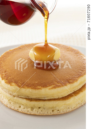 積み重ねたホットケーキにメープルシロップをかけて食べる 71607290