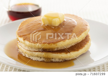 積み重ねたホットケーキにメープルシロップをかけて食べる 71607299