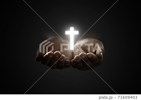 Human hands praying to god with shiny Christian Cross Human hands praying to god with shiny Christian Cross 71609403