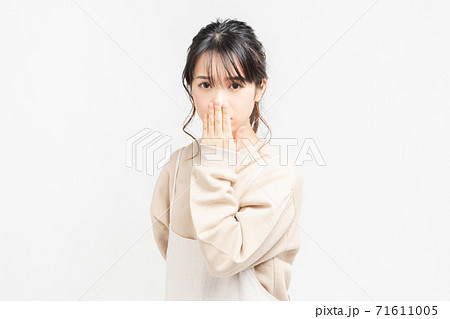 手で口を隠す若い女性の写真素材