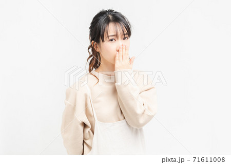 手で口を隠す若い女性の写真素材