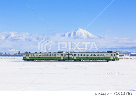磐梯山と雪原を走る只見線の列車　福島県会津美里町 71613765