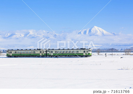 磐梯山と雪原を走る只見線の列車　福島県会津美里町 71613766