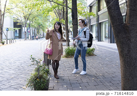 道がわからない外国人女性を道案内する日本人女性 71614810