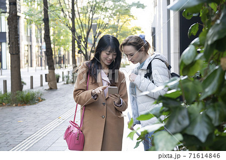 スマホの地図で外国人女性に道案内する日本人女性 スマホの地図で外国人女性に道案内する日本人女性 71614846