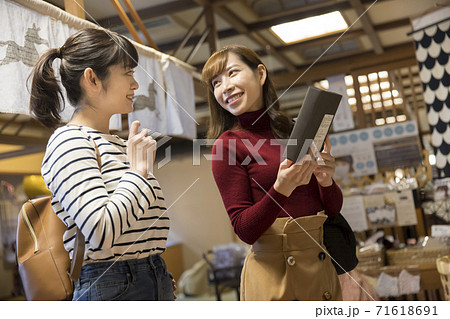 旅館のお土産コーナーでお土産を見る若い女性客の写真素材