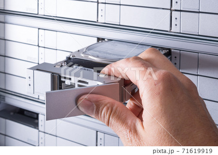 network administrator is installing new hard disk into data stor network administrator is installing new hard disk into data stor 71619919