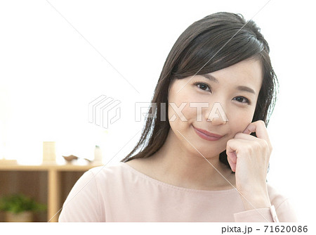 頬杖をして微笑む女性の写真素材