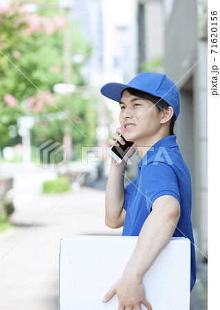 電話をする配達員の男性 71620156