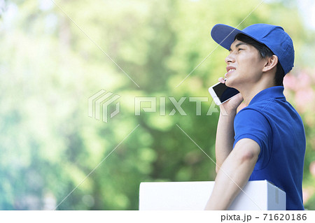 電話をする配達員の男性 71620186