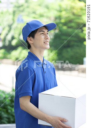 荷物を持つ配達員の男性の写真素材 荷物を持つ配達員の男性の写真素材