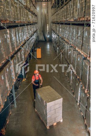 View of a person in a storage compartment with lots of containers on the shelves 71620997