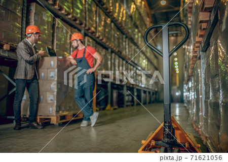 Warehouse worker and manager talking at the warehouse 71621056