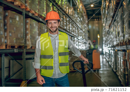 Worker in a yellow vest and helmet looking positive Worker in a yellow vest and helmet looking positive 71621152