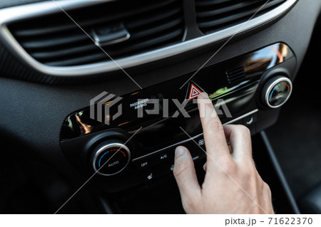 Interior view of a modern new car. Car driver pushing the attention alarm button. 71622370