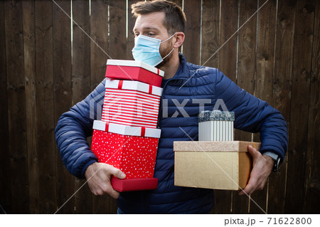 man holding pile of Christmas gift boxes 71622800
