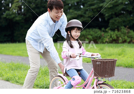 自転車の補助輪を取って練習をする親子 71623868