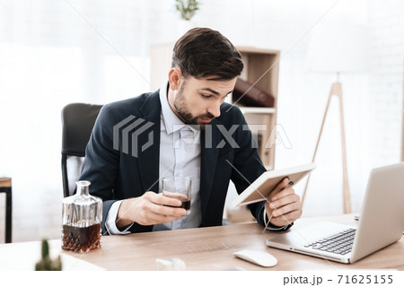 Man holds a photo frame in hand and drinks alcohol Man holds a photo frame in hand and drinks alcohol 71625155