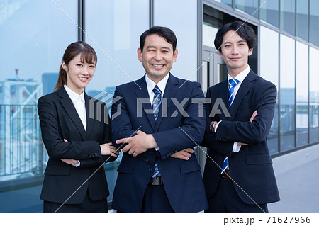 ビルの前で立つ3人のビジネスパーソン ビルの前で立つ3人のビジネスパーソン 71627966