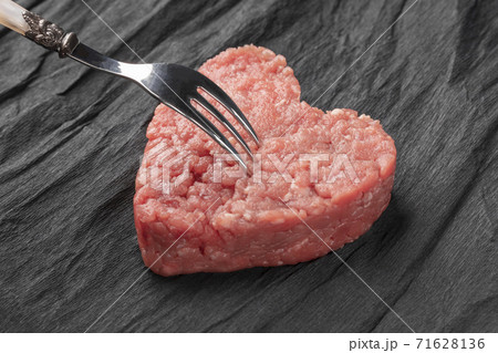 Thick hamburger meat patty on black crumpled paper. Brilliant little fork naps it 71628136