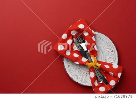 white round ceramic plates, fork with knife on a red background white round ceramic plates, fork with knife on a red background 71629379