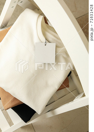 Pile of sweatshirts on white wooden chair Pile of sweatshirts on white wooden chair 71631428