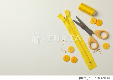 Yellow sewing supplies on white background, top view Yellow sewing supplies on white background, top view 71632648