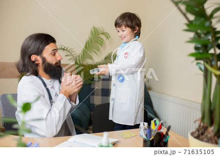 Paediatrician doctor examining a child in comfortabe medical office 71635105