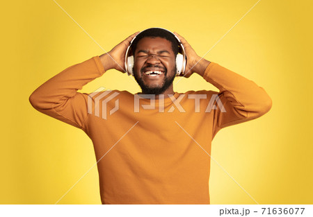 Young african-american man's portrait isolated on yellow studio background, facial expression. Beautiful male half-lenght portrait with copyspace. Young african-american man's portrait isolated on yellow studio background, facial expression. Beautiful male half-lenght portrait with copyspace. 71636077