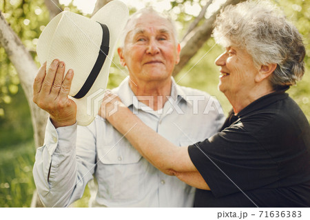Beautiful old couple spend time in a summer garden 71636383