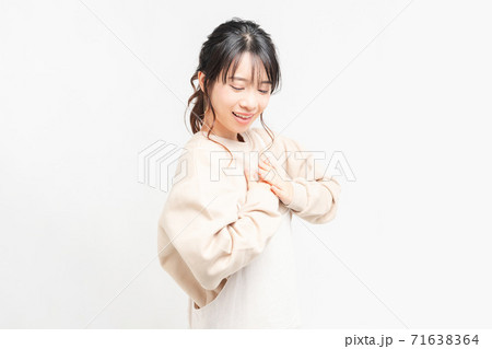 胸に手を当てる若い女性 71638364