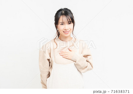 胸に手を当てる若い女性 71638371