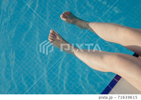 cropped young european woman kicks in the pool splashes water. Concept, carefree, summer, vacation cropped young european woman kicks in the pool splashes water. Concept, carefree, summer, vacation 71639615