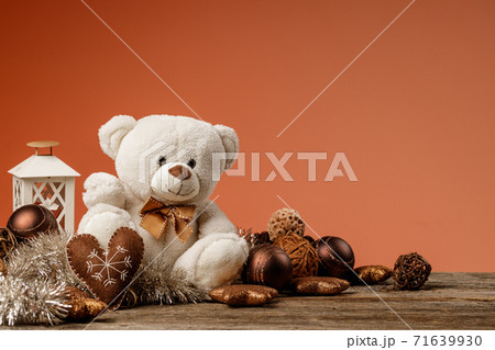 White or light brown adorable teddy bear with christmas decorations and gifts. Holiday concept with toy plush bear and christmass gifts on the wood table. 71639930