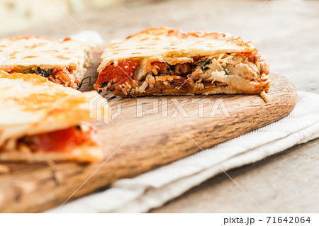 pile of quesadillas with chicken and vegetables on the rustic board 71642064