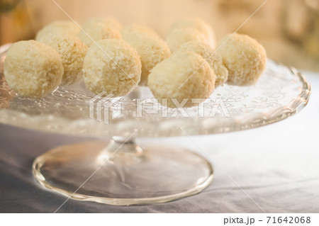 Cakes with coconut truffles in the evening light on a stand 71642068
