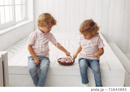 Cute children eating cookies at home 71643893