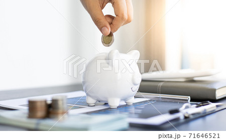 Businessman's hand holds the money in the piggy bank for saving money for future use, saving money for finance accounting concept. 71646521