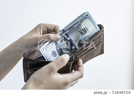 Businessman with a brown purse and a 100 dollar banknote, Saving money and spending using cash concept. Businessman with a brown purse and a 100 dollar banknote, Saving money and spending using cash concept. 71646550