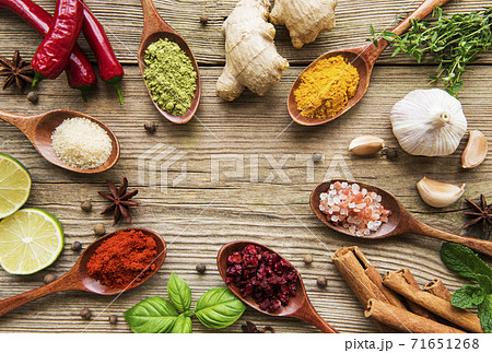 Various colorful herbs and spices on wooden table 71651268