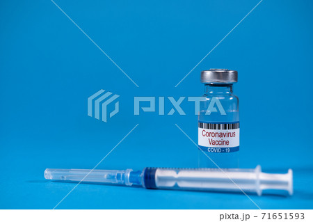 Invented coronavirus covid-19 vaccine in glass medicine bottle, syringe for injection on blue background with space for text. Concept of victory over epidemic of Sars-nCoV-2. virus 2019-nCoV defeated 71651593