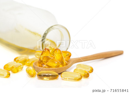 Bottle of fish oil and omega 3 in a wooden spoon Bottle of fish oil and omega 3 in a wooden spoon 71655841